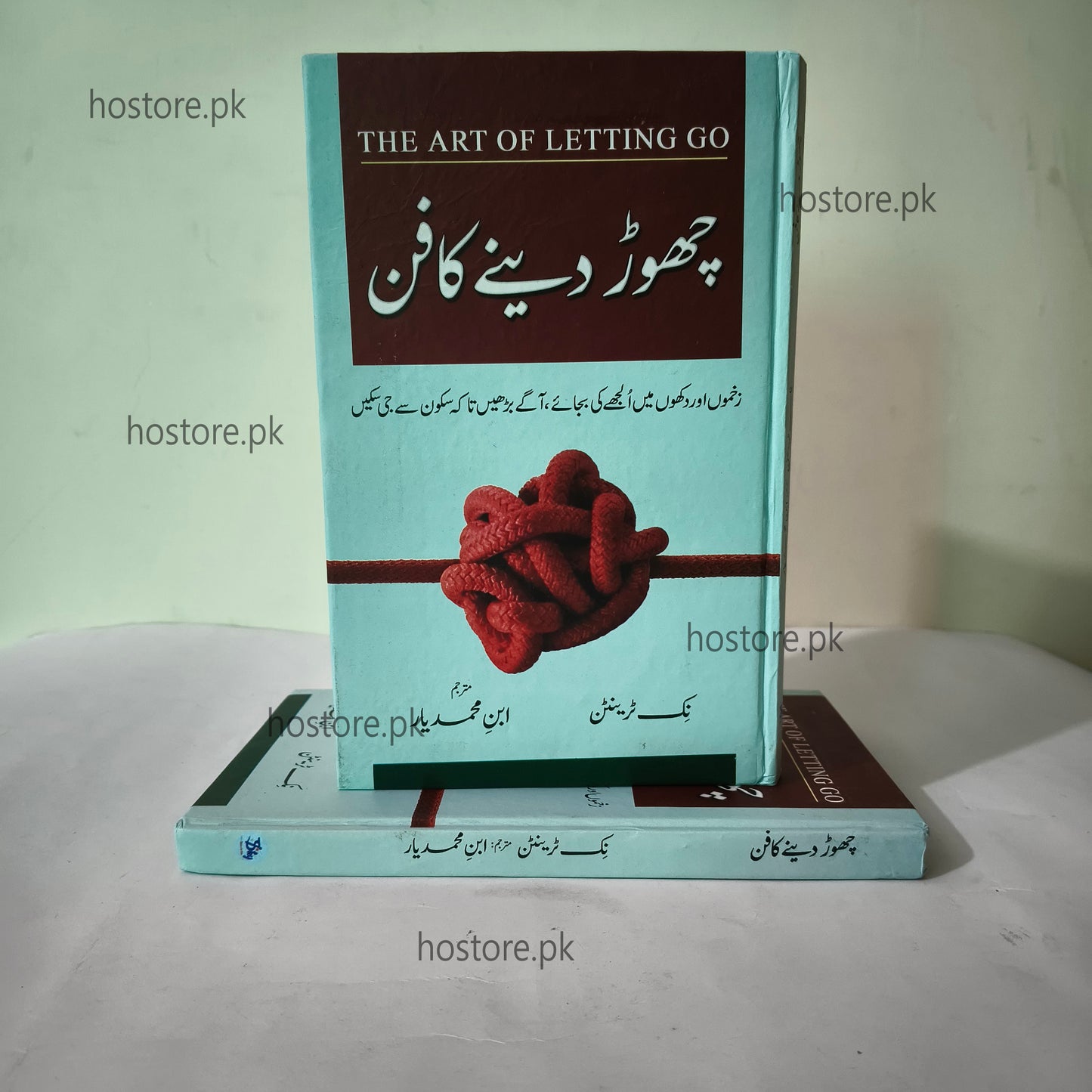 Book titled 'The Art of Letting Go' with a red knot design on a light green background.